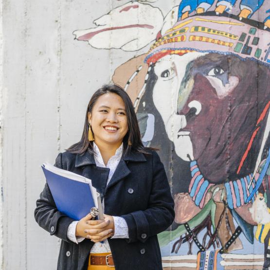 Student in front of indigenous mural