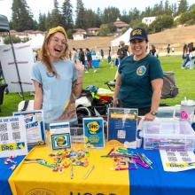 Two individuals standing behind a table representing Disability resource center of UCSC