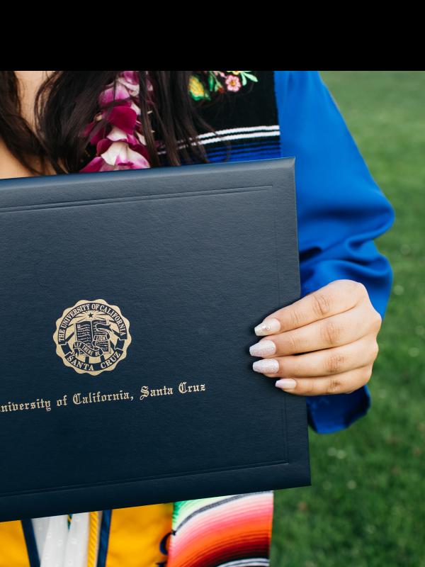 An individual holding a folder with the words "University of California, Santa Cruz" on it