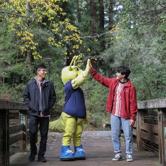 Sammy Slug mascot giving a student a high five