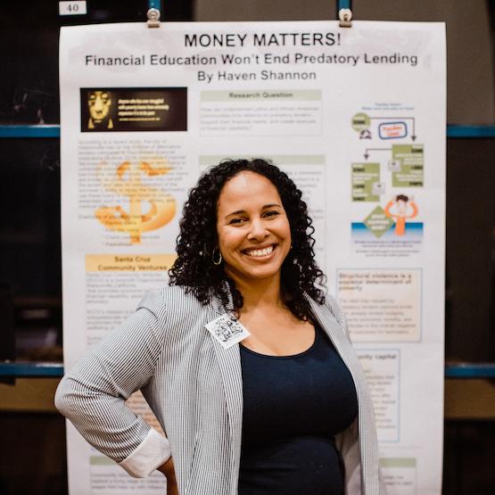 Student with "Money Matters" poster behind her
