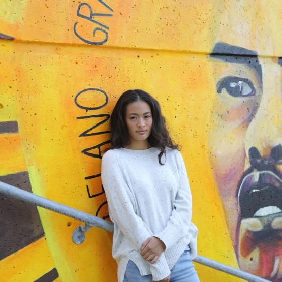 Student in front of mural