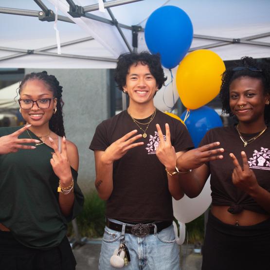 Three student smiling at the camera