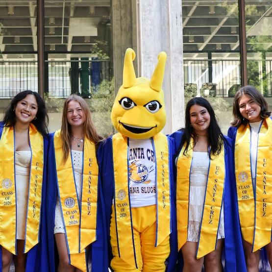 Students graduating with Sammy Slug mascot