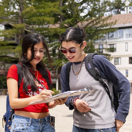 Students looking at a document together outside Porter College